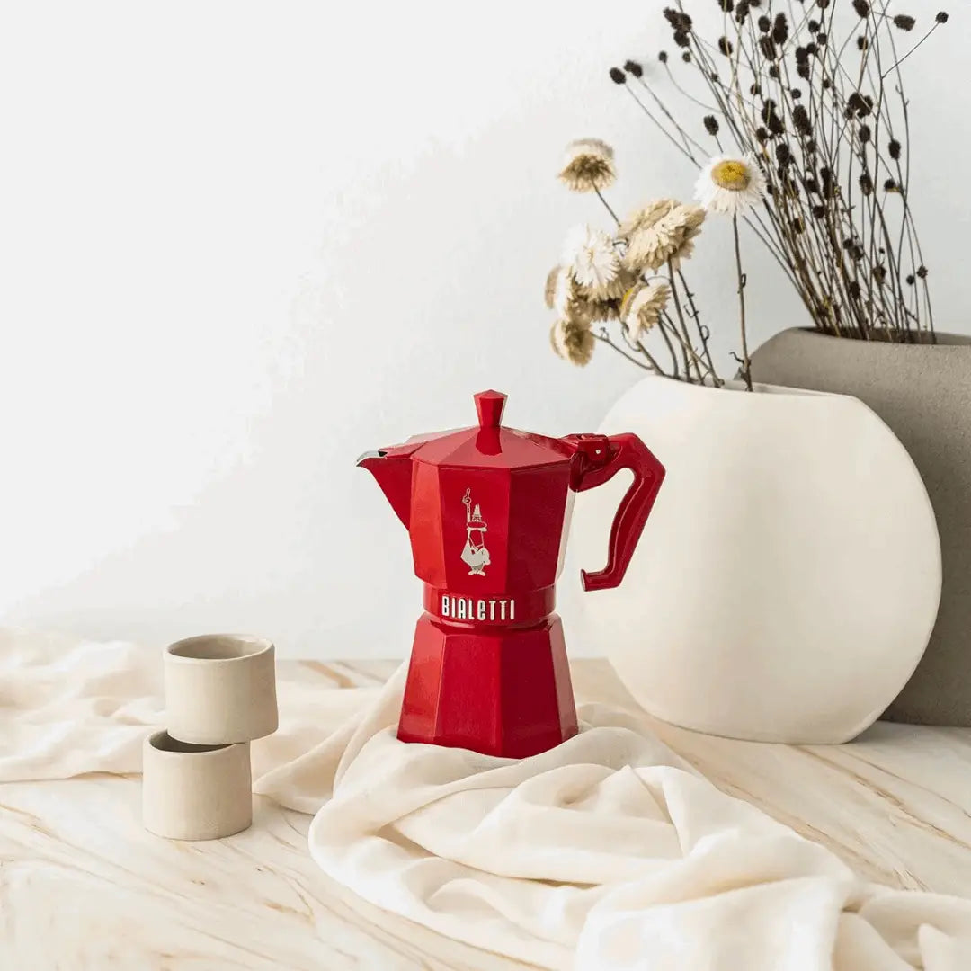 Red Bialetti Moka Express Exclusive 6-cup coffee maker by Brew Italia, featuring a classic stovetop espresso design.