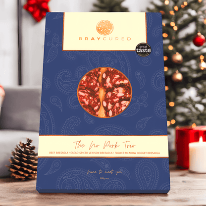 Bray Cured No Pork Tasting Trio featuring assorted pork-free charcuterie slices arranged on a holiday-themed background.
