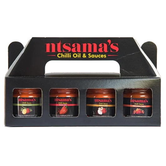 Mini chilli sauce taster set from ntsama.co.uk featuring small bottles of vibrant, spicy chilli sauces on a wooden tray.