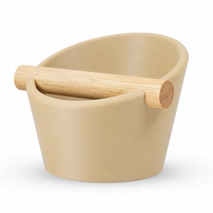 Oval coffee knock box with desert tan finish and real oak wood bar for espresso machine portafilter tamping.