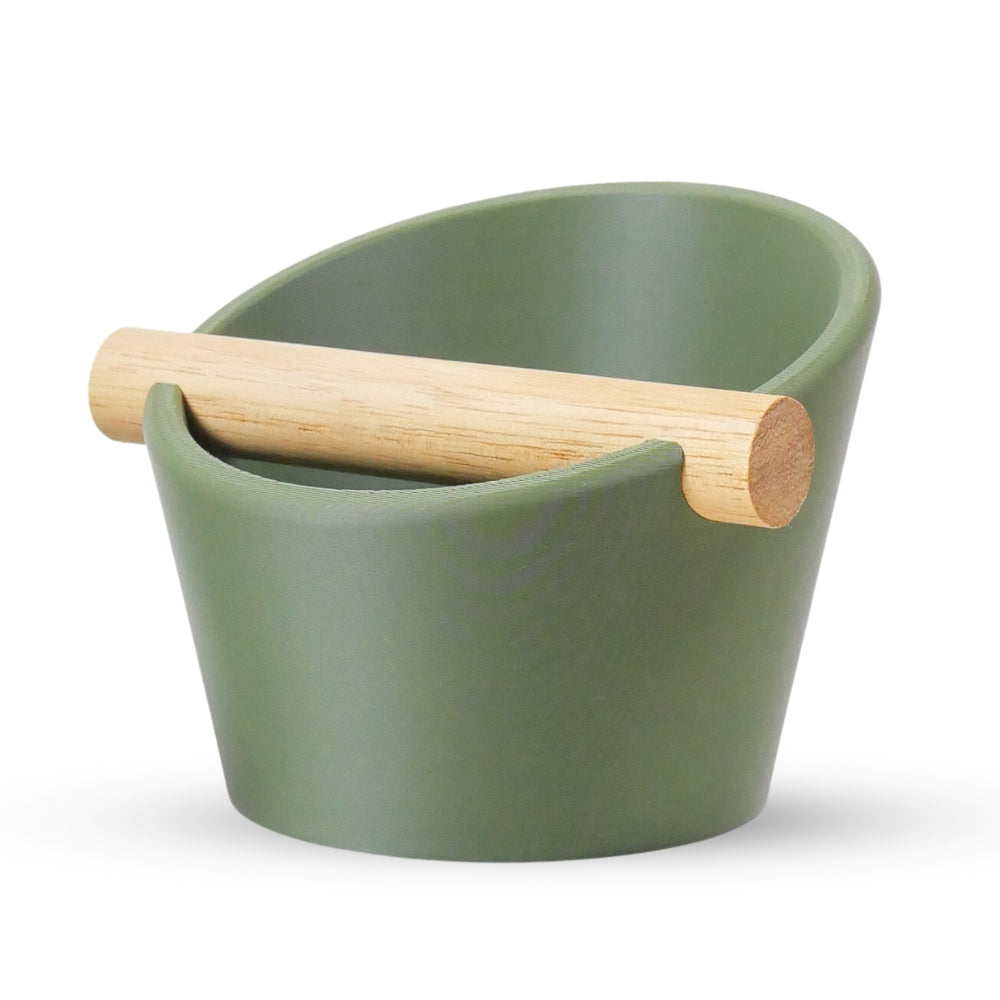 Oval Coffee Knock Box by KNOCDIC® with a sleek olive green finish and a real oak wood bar for espresso puck disposal.
