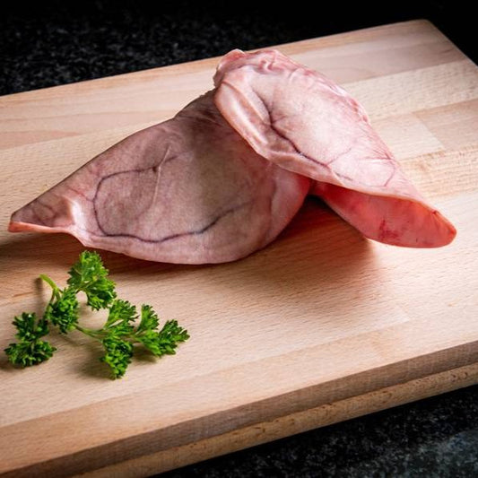 2 pigs earson a wooden cutting board with parsley