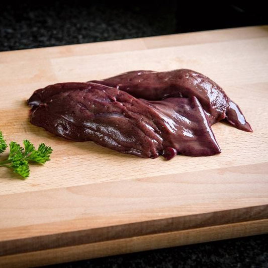 Raw liver on a wooden cutting board with parsley