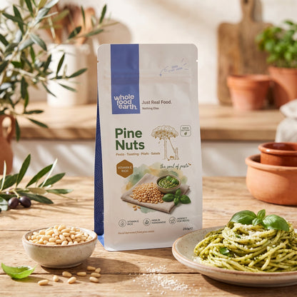 Whole Food Earth pine nuts spread out in a bowl, showcasing their small, creamy-colored seeds in a natural setting.