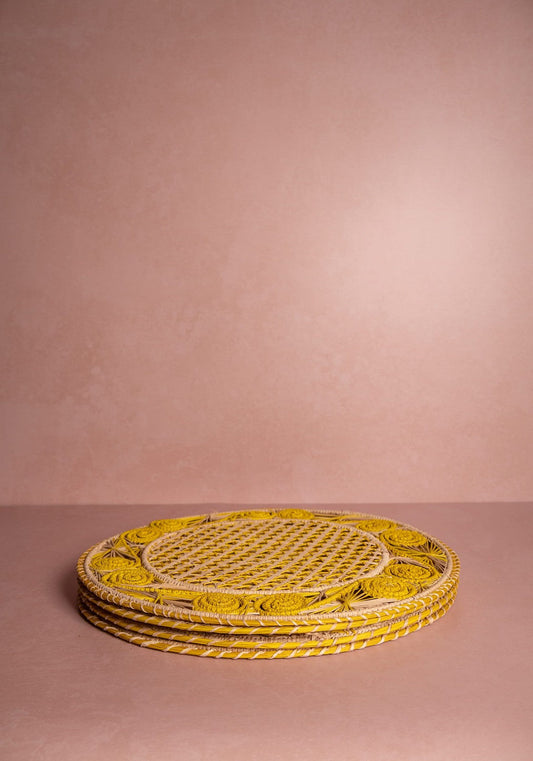 Set of four yellow Atlántico Iraca woven placemats by Casa, featuring intricate handcrafted weaving for dining table decor.