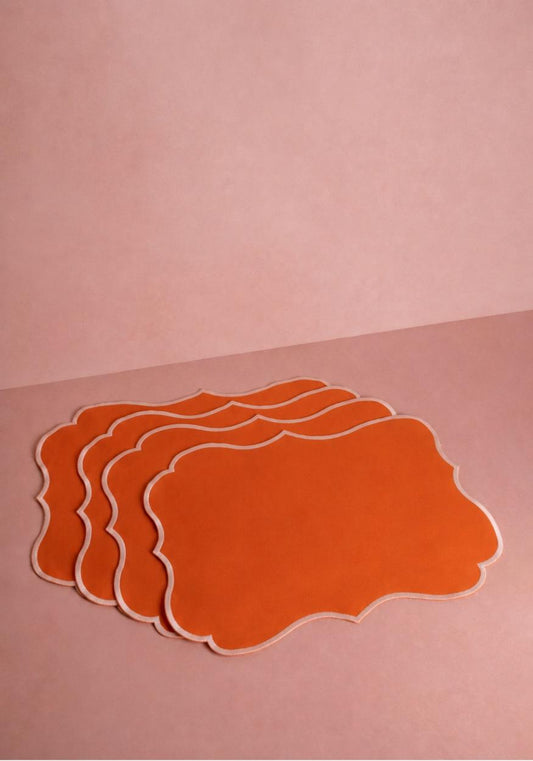 Set of four papaya-colored placemats by Casa by Josephine Jenno, featuring vibrant orange table decor.