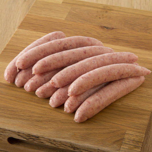 Primrose Herd cranberry and rosemary pork chipolata sausages, cooked and arranged on a plate.