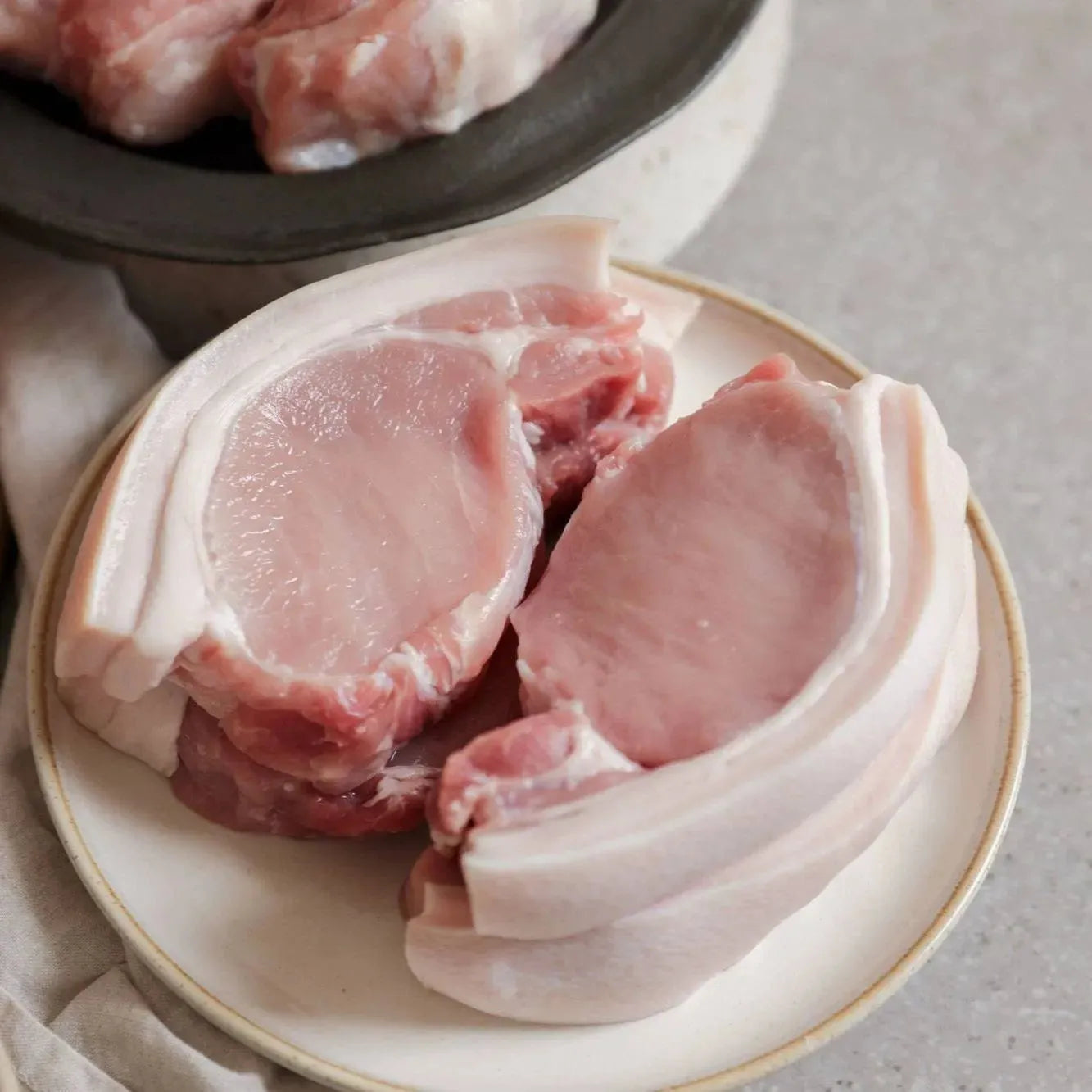 Primrose Herd pork loin steaks, raw and boneless, with a pinkish color and marbling, ready for cooking.
