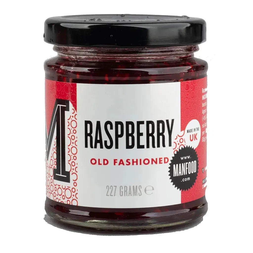 Jar of Manfood Raspberry Old Fashioned Jam with visible fresh raspberries and a rustic label on a wooden surface.