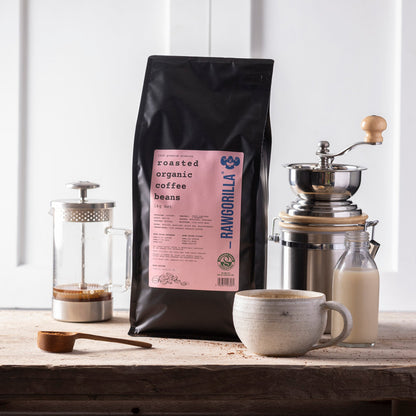 Organic roasted whole coffee beans from RawGorilla, 1kg, by Whole Food Earth, showing shiny, dark roasted coffee beans in a close-up image.