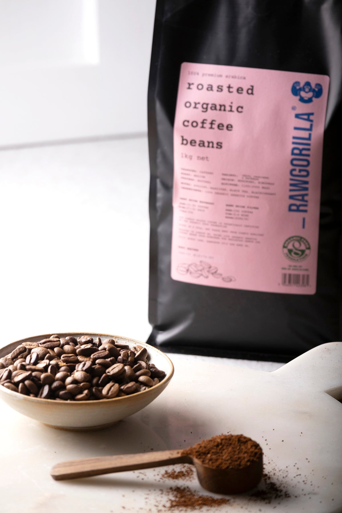 Organic roasted whole coffee beans from RawGorilla, 1kg, by Whole Food Earth, showing glossy dark brown beans in a close-up image.