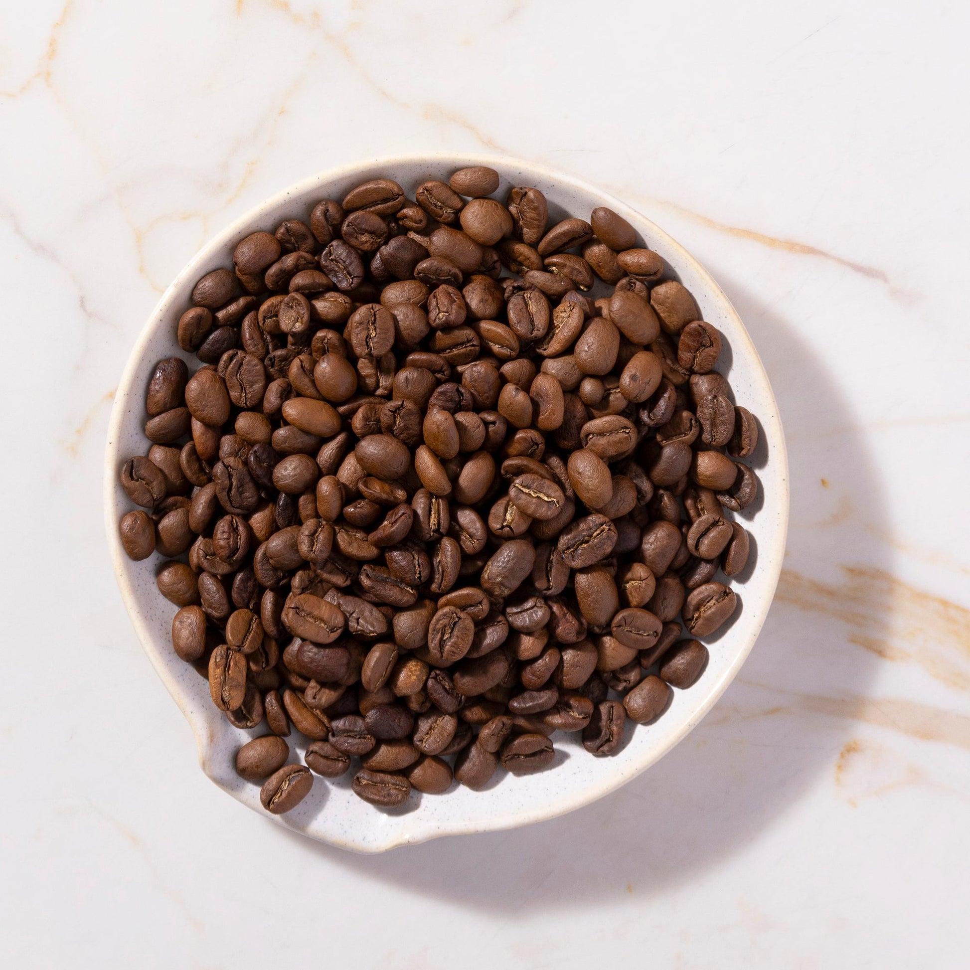 Bag of roasted organic whole coffee beans from RawGorilla, showing dark roasted coffee beans in a clear bag.