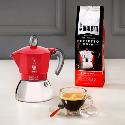 Red Bialetti Moka Induction stovetop coffee maker from Brew Italia, showcasing its classic design and compact size for brewing coffee.