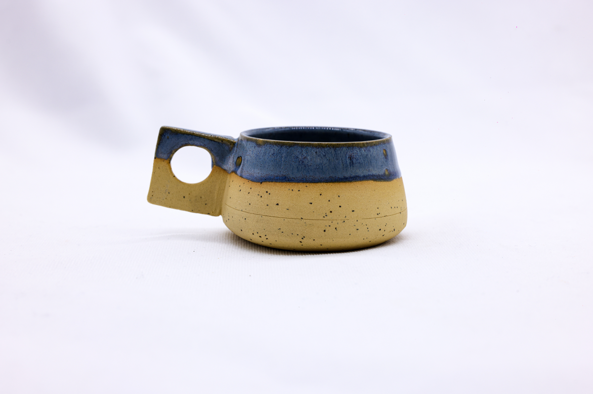 Handmade TerraBlu Formo ceramic stoneware coffee mug by Ribera Handmade Ceramics showing a glazed blue finish and ergonomic handle.