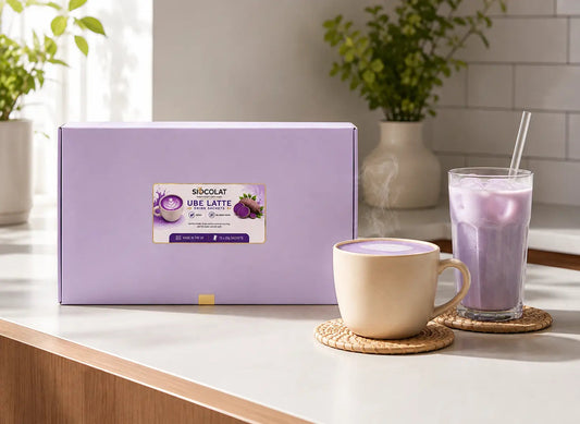 Vegan purple yam instant latte sachets by Siocolat, sugar-free and purple in color, with a cup of prepared Ube Latte drink.