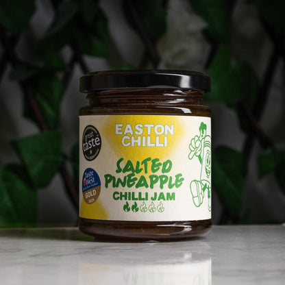 Easton Chilli salted pineapple chilli jam jar with vibrant label and spoon, showcasing the spicy-sweet condiment's texture and ingredients.