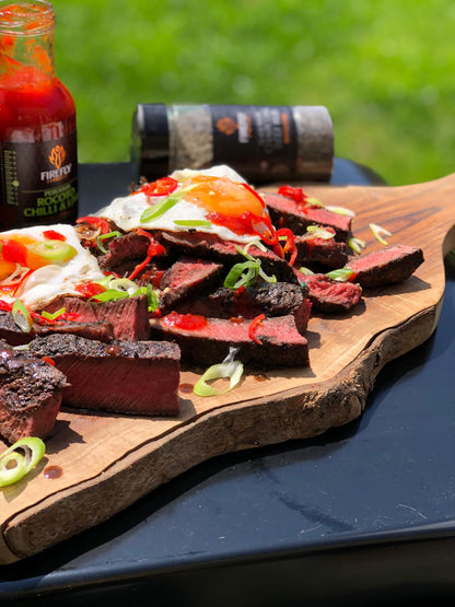 Peruvian Rocoto Sweet Chilli & Lime Sauce by FireFly Barbecue drizzled over a steak, showcasing vibrant red sauce with chili and lime flavors.