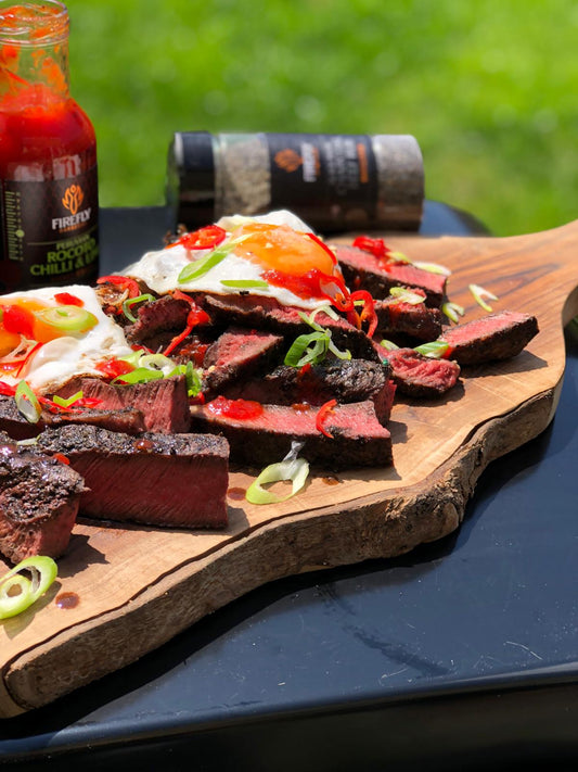 Peruvian Rocoto Sweet Chilli & Lime Sauce by FireFly Barbecue drizzled over a steak, showcasing vibrant red sauce with chili and lime flavors.