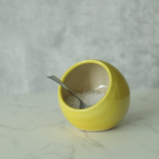 Sun yellow classic salt pig with a small spoon from Katie L Thompson Designs, featuring a square-shaped ceramic design.