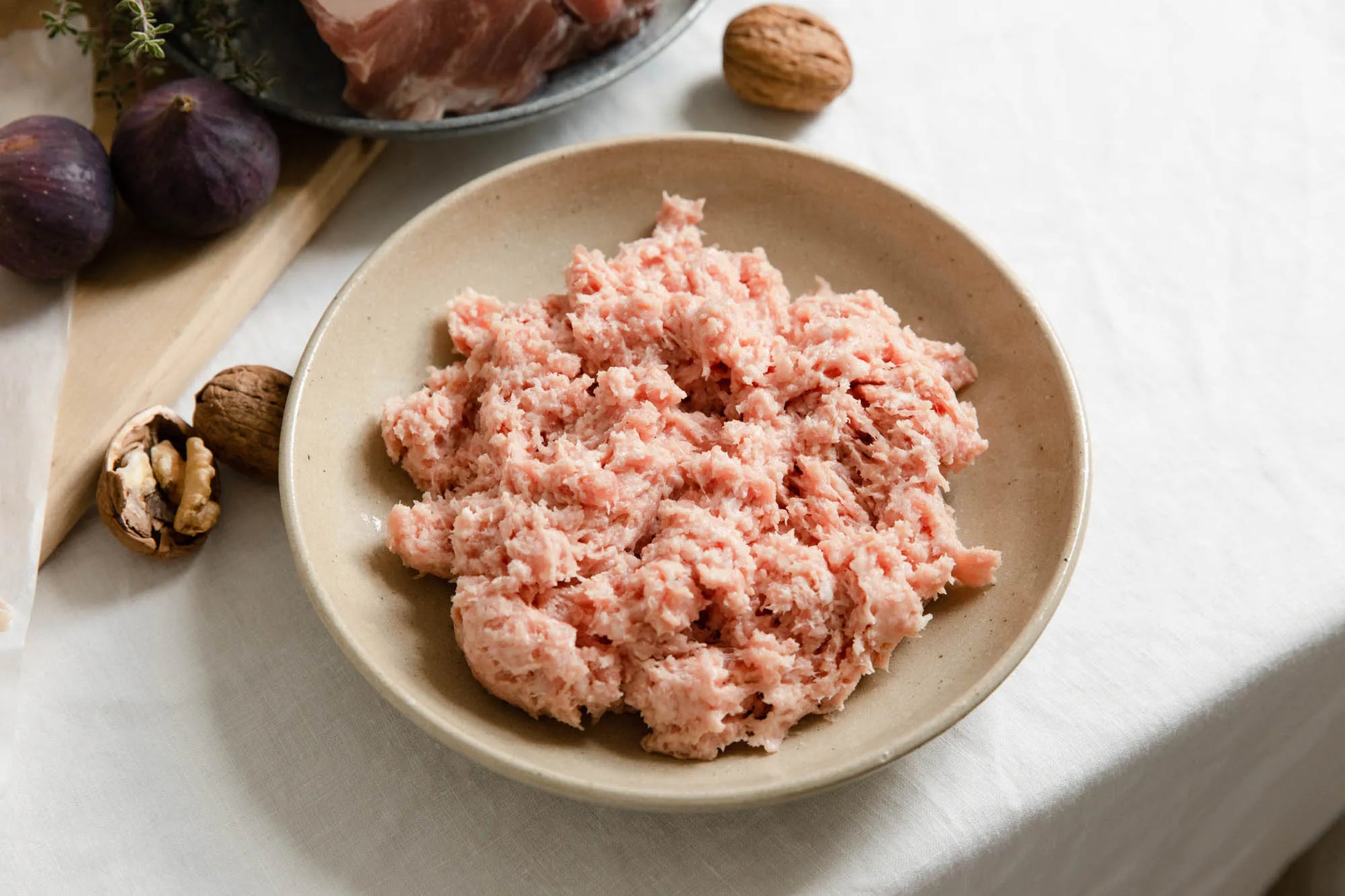Primrose Herd cranberry and rosemary sausage meat, fresh raw sausage meat with visible herbs and cranberry pieces.