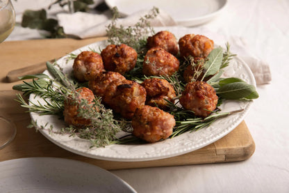 Primrose Herd cranberry and rosemary sausage meat balls, raw sausage meat with visible cranberry and rosemary pieces, ready for cooking.