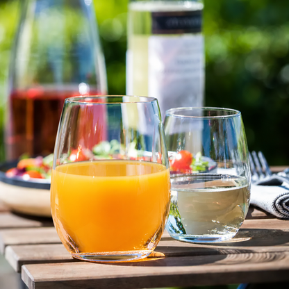 Set of six Amber Tumblers by Glassware UK filled with orange juice, 440ml capacity, showcasing modern glassware design.
