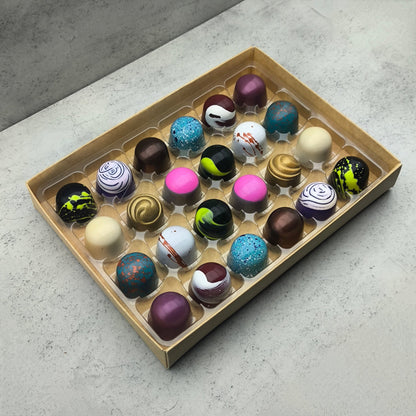 Assorted Trufflus Chef's Selection of 24 artisan bonbons in a decorative box, showcasing a variety of colorful chocolate treats.