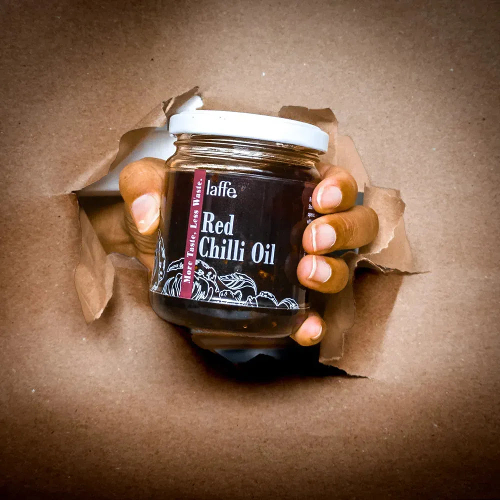 Bottle of Laffe sustainable red chilli oil with red chili peppers and oil visible in a clear glass container.
