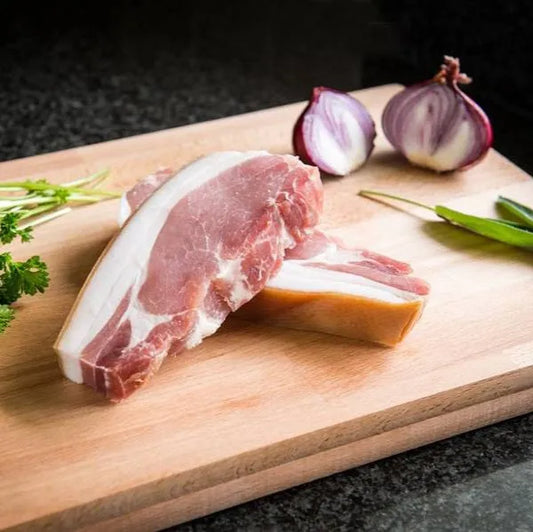 Smoked bacon chop from Primrose Herd showing crispy, sliced bacon with smoky flavor and rich marbling.