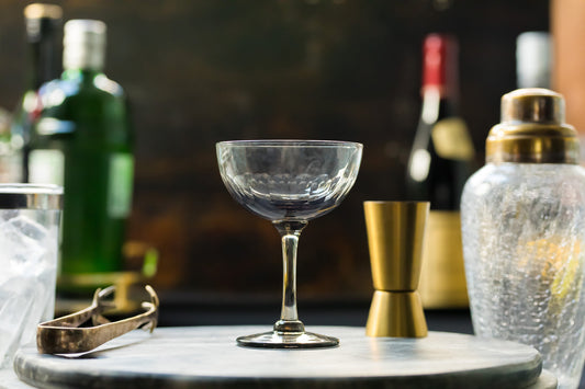 Four smoky crystal champagne saucers with lens design by The Vintage List, showcasing elegant, translucent glassware for celebratory drinks.