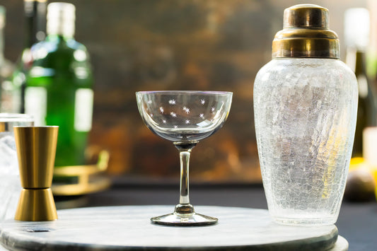 Four smoky crystal champagne saucers with star designs by The Vintage List, showcasing elegant glassware for special occasions.