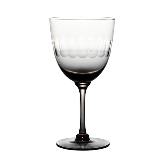 Four smoky crystal wine glasses with lens design from The Vintage List, showing elegant, modern glassware on a neutral background.