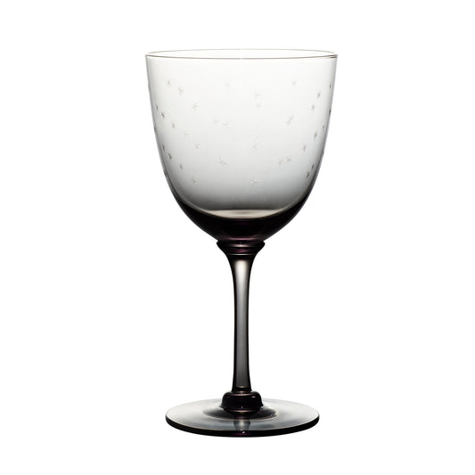Four smoky crystal wine glasses with star designs by The Vintage List, showcasing elegant glassware on a neutral background.