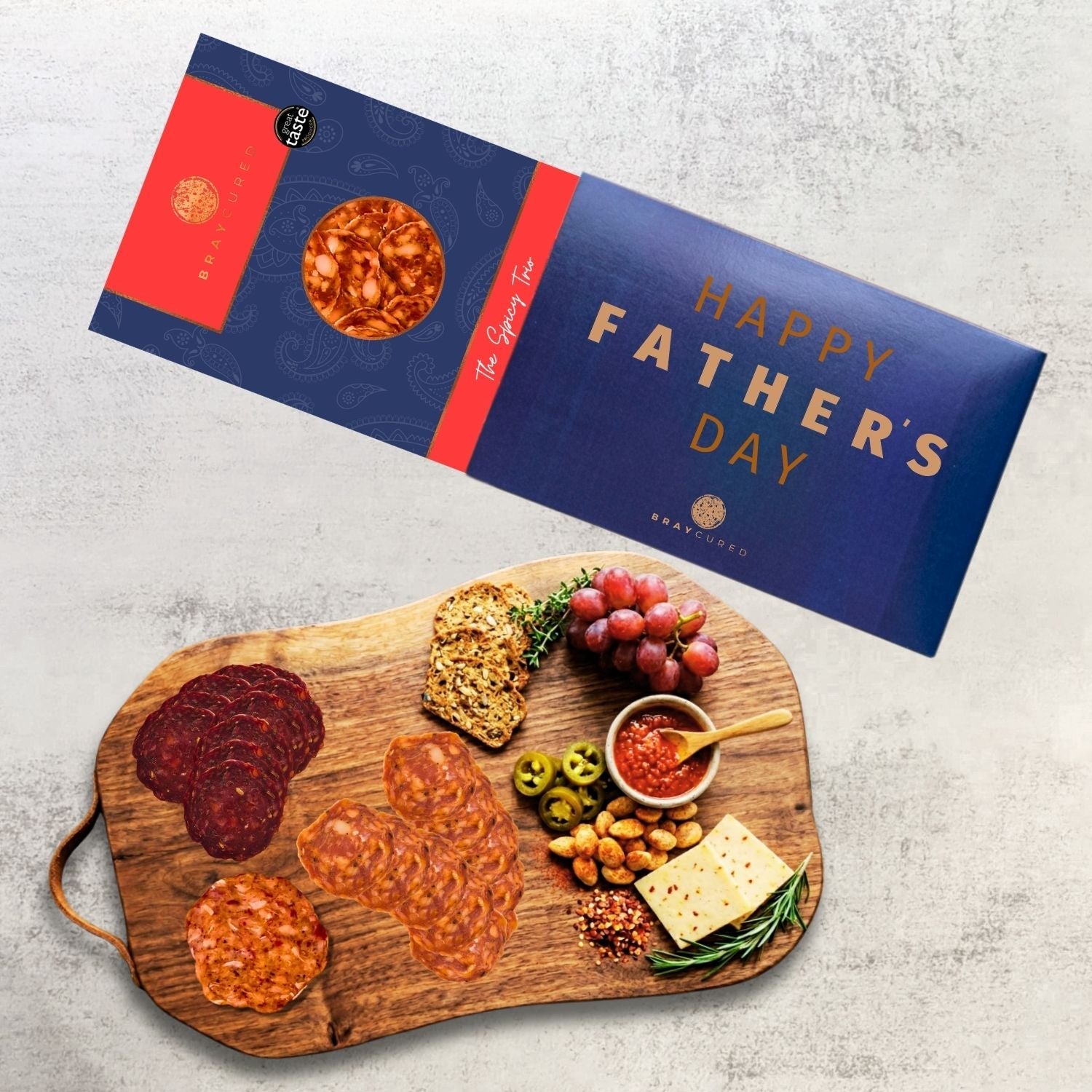Bray Cured spicy tasting charcuterie trio on a wooden board with a Father's Day sleeve, featuring assorted spicy cured meats.