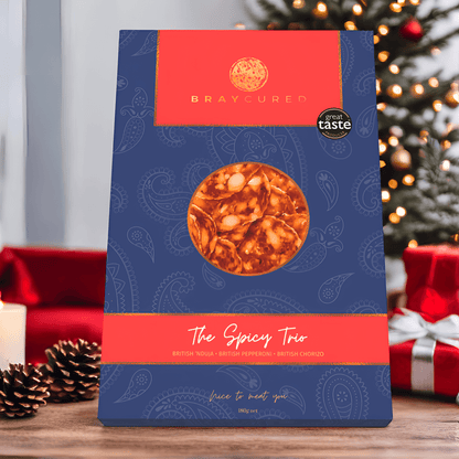 Bray Cured spicy charcuterie tasting trio with assorted cured meats and spices, displayed on a festive Christmas scene.