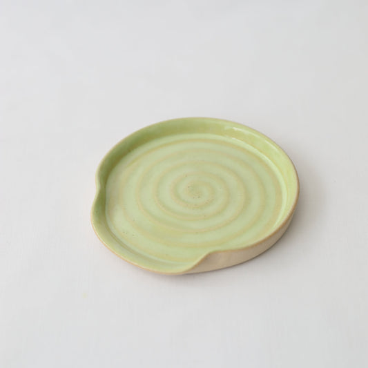 Spring green ceramic spoon rest by Katie L Thompson Designs, featuring a classic shape for kitchen organization and decor.
