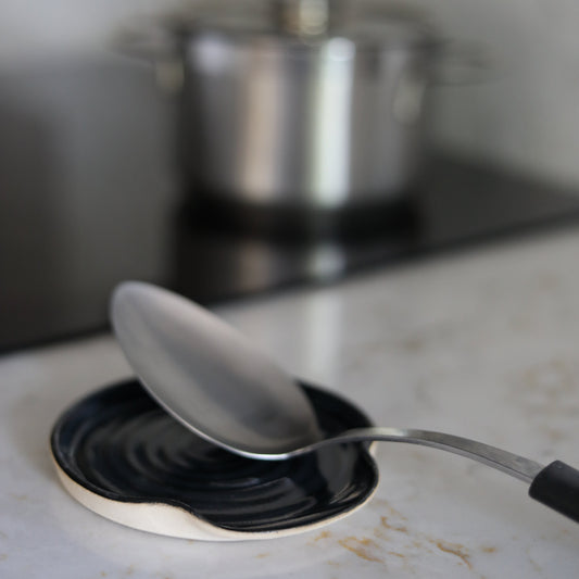 Jet black ceramic spoon rest from Katie L Thompson Designs, classic kitchen accessory for holding spoons and utensils.