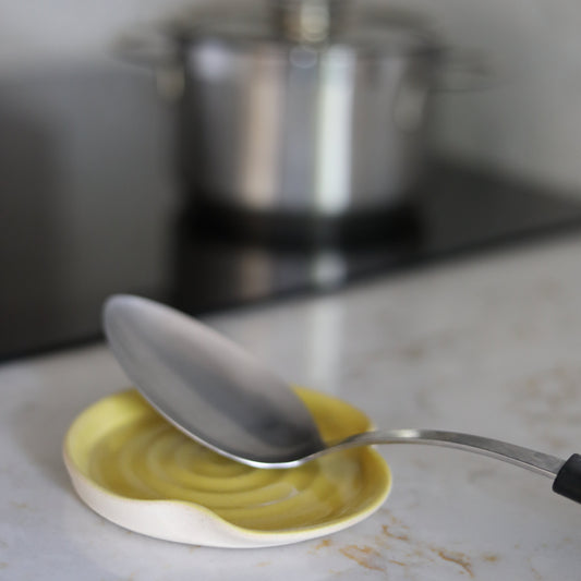 Sun yellow classic spoon rest by Katie L Thompson Designs, ceramic kitchen accessory with a cheerful sun-inspired design.