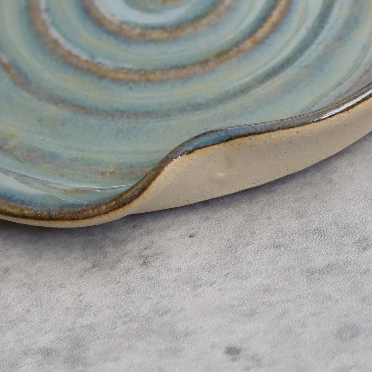 Close-up of a seafoam blue ceramic spoon rest with a classic design from Katie L Thompson Designs.
