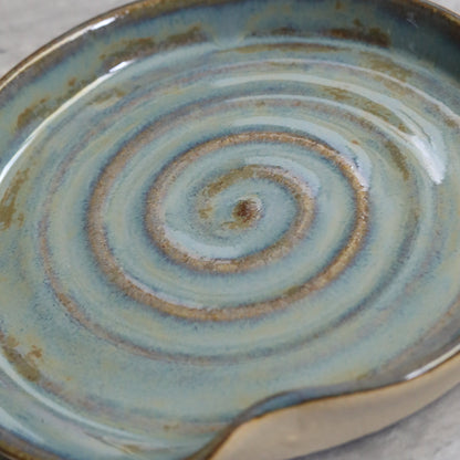 Seafoam blue ceramic spoon rest with a spiral design by Katie L Thompson Designs, ideal for kitchen countertop use.