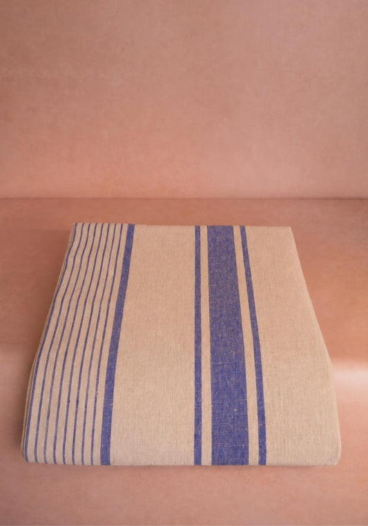 Blue and white striped Amelia linen tablecloth by Casa Josephine Jenno, showing a close-up of the fabric's pattern.