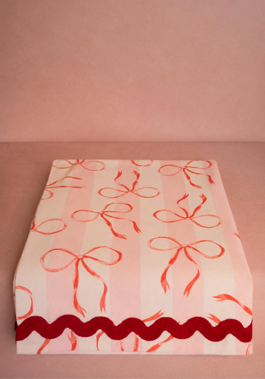 Pink cotton Kensington Bow tablecloth with ric rac trim, designed by Casa by Josephine Jenno, featuring a charming bow pattern.