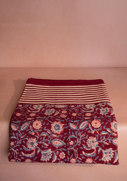 Maroon Casa by Josephine Jenno tablecloth draped over a dining table, showing its smooth fabric and rich color.