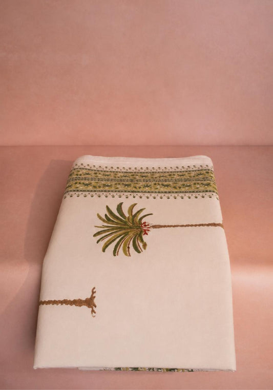 Casa by Josephine Jenno palm tree tablecloth with tropical design, perfect for a vibrant dining table setting.