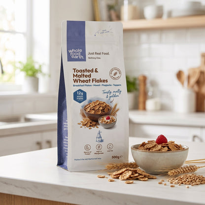 Whole Food Earth toasted and malted wheat flakes cereal in a bowl with milk, showcasing golden toasted wheat flakes.