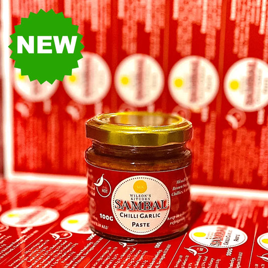Wilson’s Kitchen Spicy Sambal artisan chili sauce in a jar with a vibrant red color and fresh chili peppers visible.