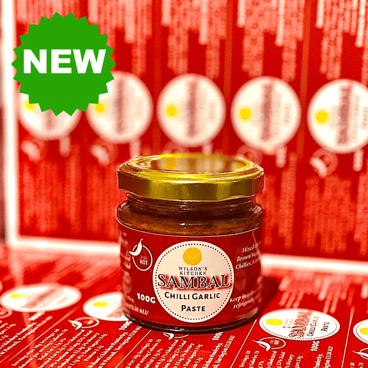 Bottle of Wilson’s Kitchen Spicy Sambal artisan chili sauce with vibrant red chili peppers and a rustic label.