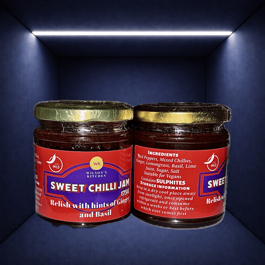 Wilson’s Kitchen Mild Sweet Chilli Jam in a glass jar, showcasing the vibrant red chili jam with a spoon for serving.