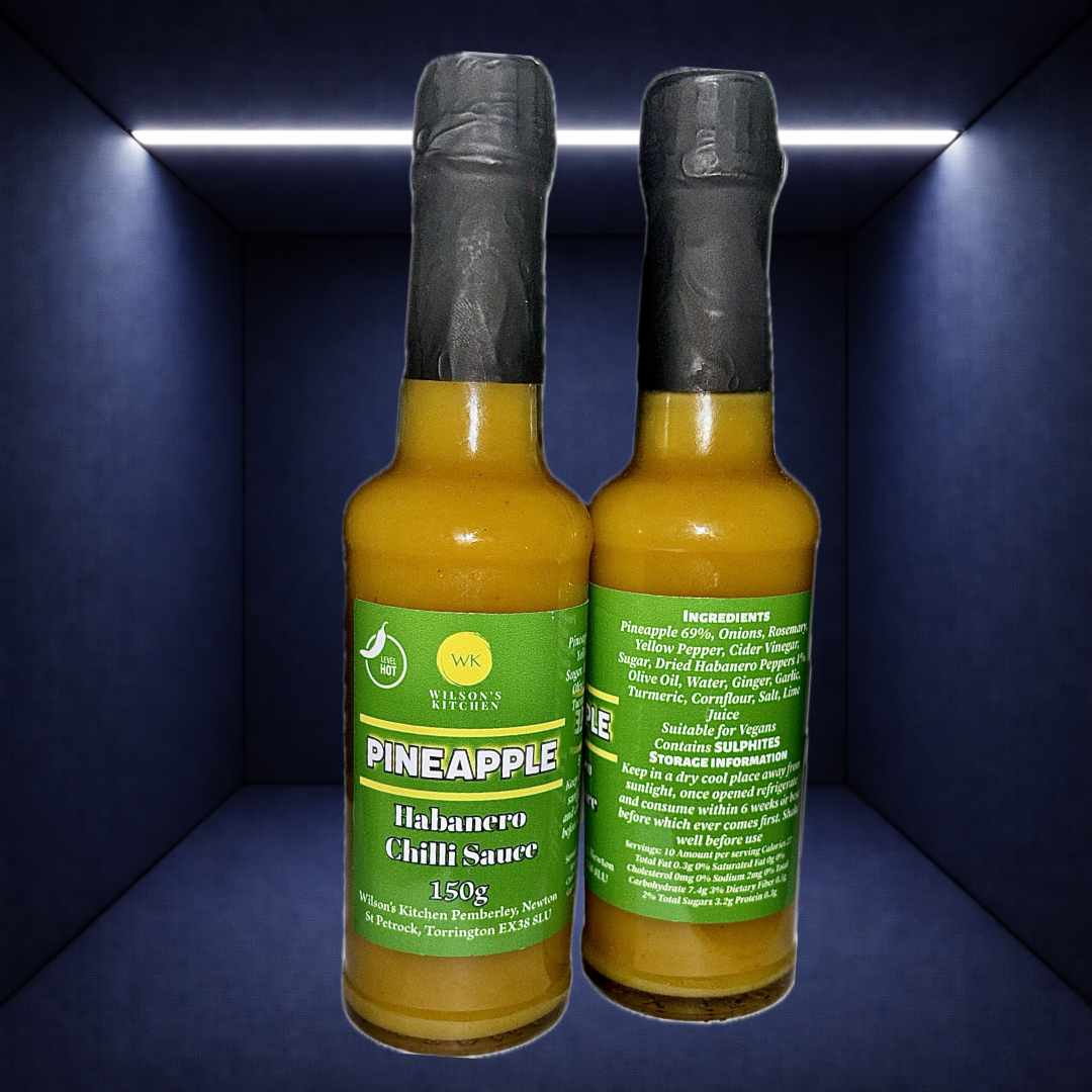 Wilson’s Kitchen Pineapple Habanero Sauce in a glass bottle, showcasing vibrant yellow pineapple and fiery habanero peppers.
