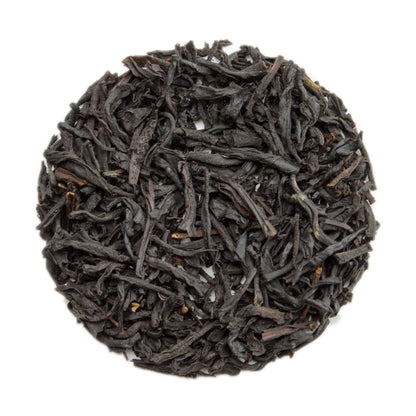 Cup of vanilla black tea by PekoeTea Edinburgh, showcasing a dark brewed tea infused with vanilla flavor in a clear glass mug.
